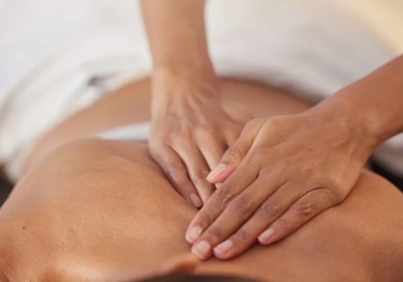 Massage therapist applying pressure on back